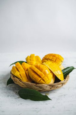 Beyaz ahşap arka plan üzerinde sepette Mango