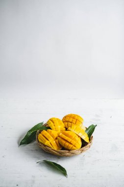Beyaz ahşap arka plan üzerinde sepette Mango
