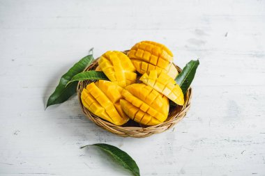 Beyaz ahşap arka plan üzerinde sepette Mango