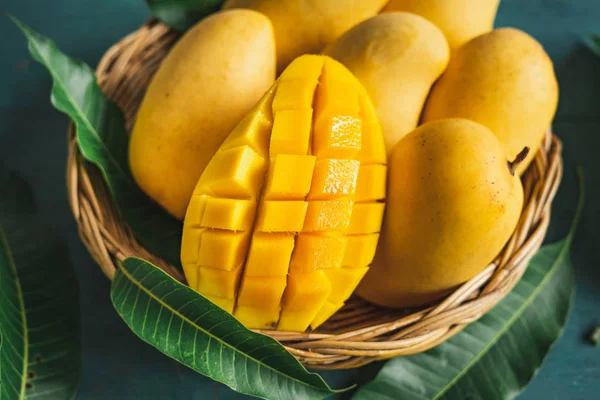 Yeşil bir ahşap üzerinde bir sepet içinde Mango