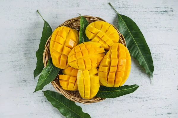 Beyaz ahşap arka plan üzerinde sepette Mango