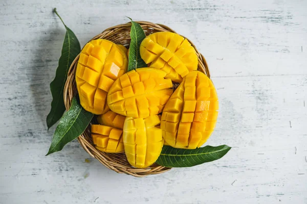 Beyaz ahşap arka plan üzerinde sepette Mango