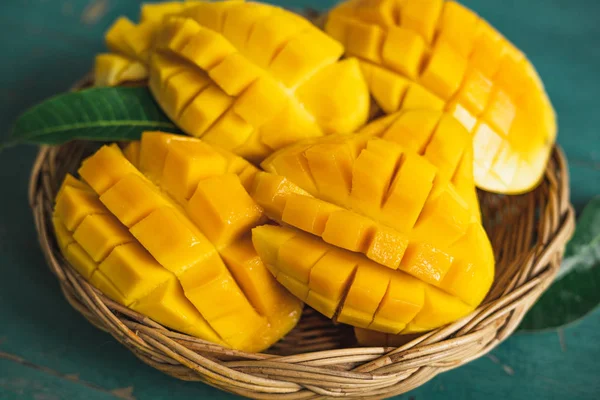 Yeşil bir ahşap üzerinde bir sepet içinde Mango