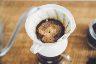 Damla kahve ahşap arka plan üzerinde kahve bir fincan yapmak