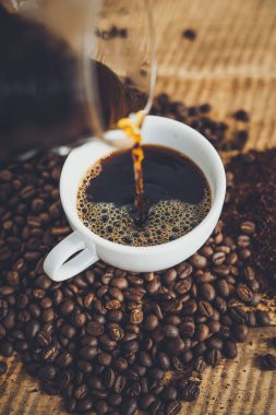 Damla kahve ahşap arka plan üzerinde kahve bir fincan yapmak