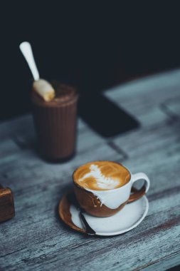 Bir fincan sıcak latte kahve bir kahve dükkanında ahşap bir masada