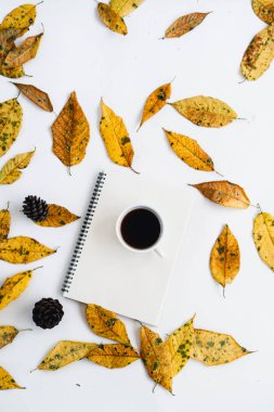 Sarı yapraklar beyaz ve sonbaharda ve bir fincan kahve