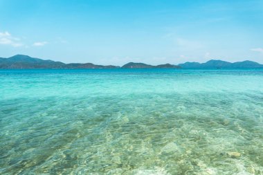 Adadaki berrak su, parlak mavi deniz. 