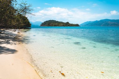 Adadaki berrak su, parlak mavi deniz. 