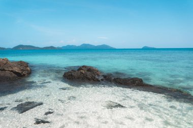 Adadaki berrak su, parlak mavi deniz. 