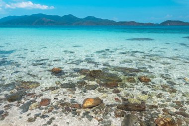 Adadaki berrak su, parlak mavi deniz. 