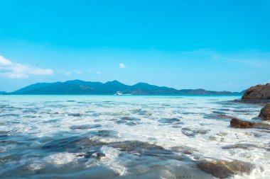 Adadaki berrak su, parlak mavi deniz. 
