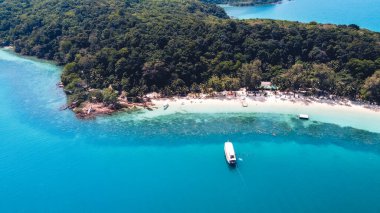 Adada berrak su, açık mavi deniz ve sahil.