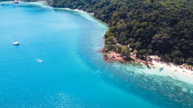 Adada berrak su, açık mavi deniz ve sahil.