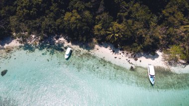 Adada berrak su, açık mavi deniz ve sahil.