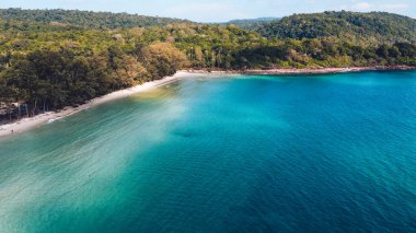 Adada berrak su, açık mavi deniz ve sahil.