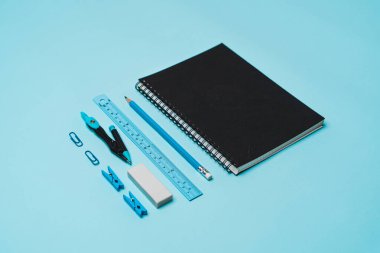 Kırtasiye - mavi zemin üzerinde kitap, kalem, cetvel.