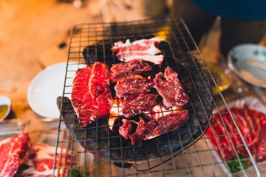 Evdeki kömür ocağında ızgara et dilimleri.