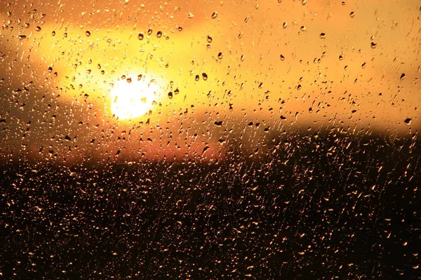 窗外雨在日落的背景下 雨中雨点落在玻璃上 雨中窗外的日落 水滴的明亮质地 — 图库照片