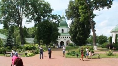 Novhorod-Siverskyi, Ukrayna Novhorod-Siverskyi 05 Temmuz 2018: Spaso-Preobrazhensky erkek manastır. İnsanlar kilise Manastırı çan sesleri için bırakın. Pazar Manastırı hizmetinde. Büyük ağaçlar ile dini yer