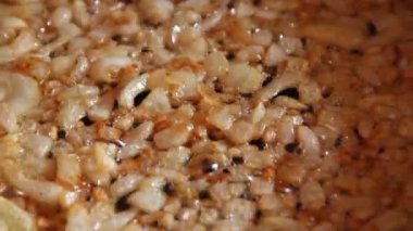 Soğan dilimleri closeup kalbur içinde kavrulmuş. Lezzetli yemek için malzemeler. Soğan tavada kızartma. Soğan kızartma işlemi
