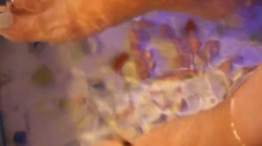 Genç kadın Masaj küçük balıklar ile alma. Balık ile soyulması. Tıbbi prosedür zevk kız. Ayak masajı balık akvaryum closeup ile. Balık spa yordamı