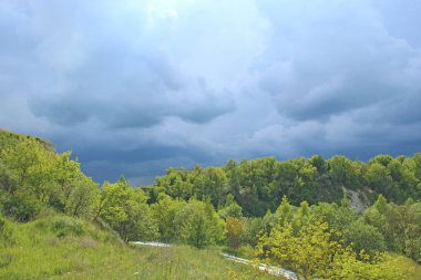 Görebilsin ile üzerinde yeşil orman manzara. Yeşil vejetasyon yukarıda fırtına bulutu. Koyu mavi bulutlar ile güzel raincloud üzerinde. Doğa yağmur önce. Daha önce sağanak yağmurlu bulutlar