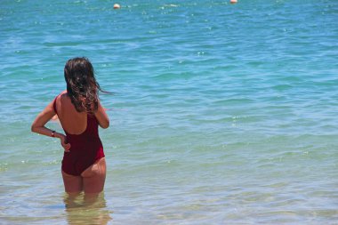 Kız güneşlenme ayakta deniz tatil sırasında. Denizde rahatlatıcı kadının. Kadının güneş, özgürlük ve yaşam. Tatil seyahat. Kadın zevk yaz açık havada