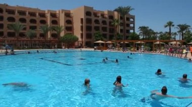 Hurghada / Mısır. 28 Temmuz 2018: insanlar yüzme havuzunda tropikal tatil köyü. Atmosfer Mısır Otel gevşeme. Yaz tatillerini zevk insanlar. Yüzme havuzuna şeffaf mavi su ile güzel manzara