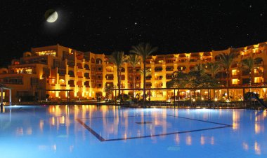 Hurghada / Mısır. 28 Temmuz 2018:Moon resort otel ve yüzme havuzu gece yukarıda. Havuzu ve akşam otel tatil. Işıklar akşam otelin havuzu suda gecede yansıtılır. Hurghada resort Otel'in parlak ışıklar