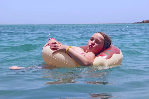 夏休みに海で膨脹可能なサークルに横たわって水で泳ぐ少女 海の上に置きます リゾートで幸せな子供時代 休暇中に海にゴム輪でリラックスしたティーンエイ ジャーの女の子 — ストック写真