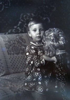 Chernihiv / Ukrayna Circa 1987: Vintage Fotoğraf bir bebek tutan küçük kız. Kız bebek ile Retro Fotoğraf. Bebek yaklaşık 1986 ile çocuk fotoğrafı küçük kız kardeşim çocukluk çağında