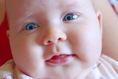 Yeni doğan bebek annesinin elleri üzerinde yalan gülümseyen yüzünü. Küçük çocuk gülümseyen kapatın. Yeni doğan bebek portresi