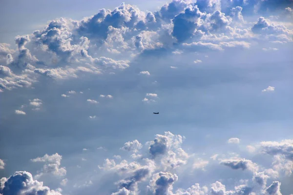 Beautiful view from window of plane. View from window of plane onto sky clouds and flying aircraft. Panorama with flying plane high in sky. Landscape with plane flying among clouds