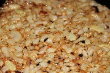 Soğan dilimleri closeup kalbur içinde kavrulmuş. Lezzetli yemek için malzemeler. Soğan tavada kızartma. Soğan kızartma işlemi