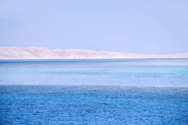 Mavi denizi ve kumlu ada manzara. Ufukta Denizde kum tepeleri. Masmavi Denizi ve kumlu ada. Farklı renkteki okyanus su. Tropikal deniz topraklardan görünümünü. Sandy beach Adası