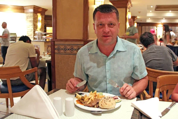 Man äter lunch på restaurang portion av pommes frites, kött och grönsaker — Stockfoto