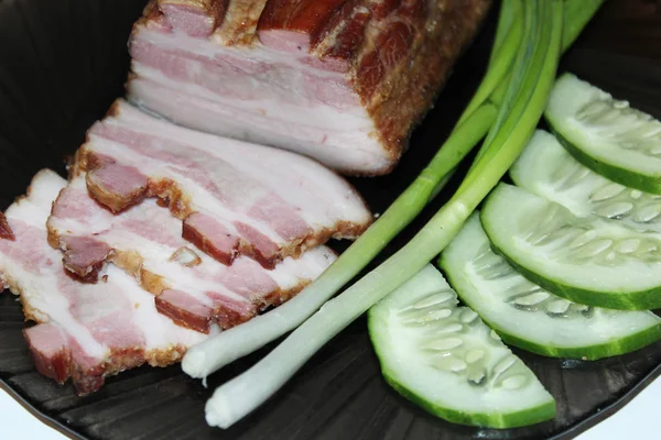 Carne cortada em uma chapa com cebolas verdes e pepinos — Fotografia de Stock