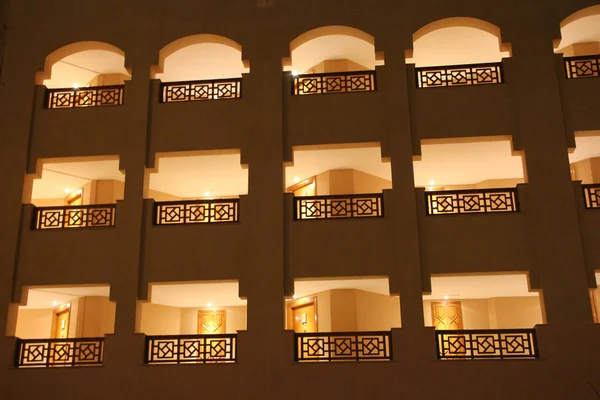 Moderno edificio del complejo con ventanas y balcones iluminados por la noche —  Fotos de Stock