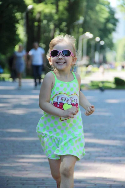 快乐的小女孩在城市公园里跑步。积极的幼稚的情绪 — 图库照片