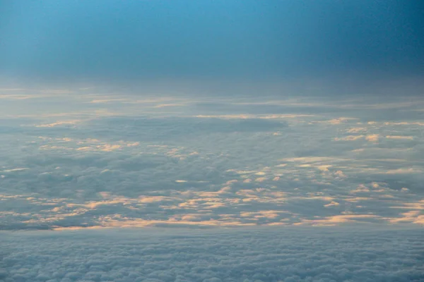 Prachtig uitzicht vanuit het raam van het vliegtuig in ochtendzon over wolken — Stockfoto