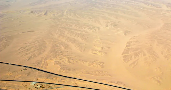 Beautiful view onto asphalt road in wild sandy lands of desert. Drone shot — Free Stock Photo