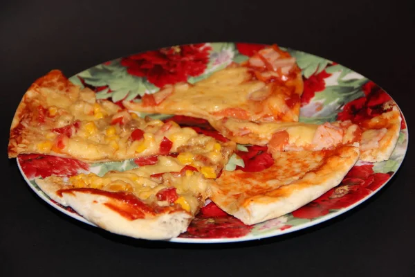 Scheiben frische, appetitliche Pizza mit leckeren Zutaten auf buntem Teller — Stockfoto