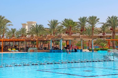 Mısır'da tropikal tatil köyü. Açık mavi su ve palmiye ağaçları ile yüzme havuzu
