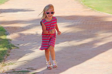 Köy yolunda koşan mutlu küçük kız. Pozitif çocuksu emitions