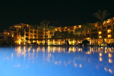 Akşamları yüzme havuzlu beş yıldızlı otel binası. Lüks otel.