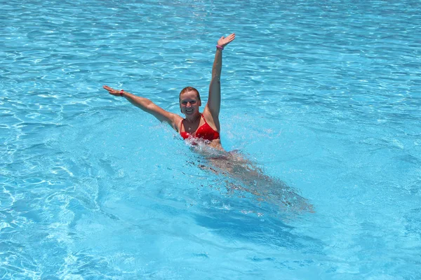 Mulher atraente nadando na piscina durante as férias. Menina mergulho na piscina — Fotografia de Stock
