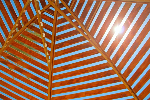 Sunbeam makes its way through wooden roof of canopy on beach — Stock Photo, Image