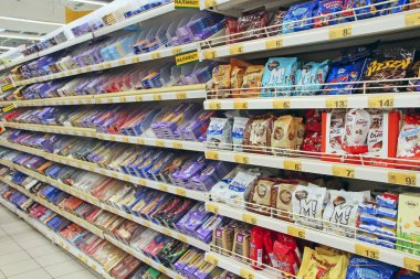 Lodz / Polonya. 19 Haziran 2019: Dükkanın tezgahında çikolata ve şeker bolluğu. Süpermarketin tezgahında çikolatalar ve şekerler. Süpermarketin şekerleme bölümünde şekerlemeler