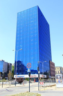 Lodz 'daki gökdelen. Lodz 'da mavi pencereli uzun bir gökdelen. Polonya 'nın Lodz şehrinde eşit pencereli modern bina